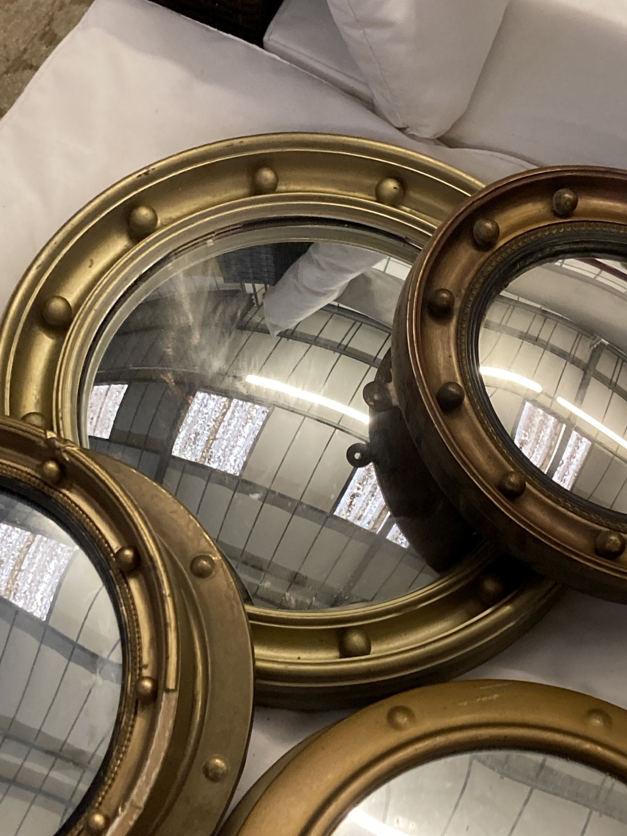 Six circular gilt and brass framed convex wall mirrors, largest 39cm diameter